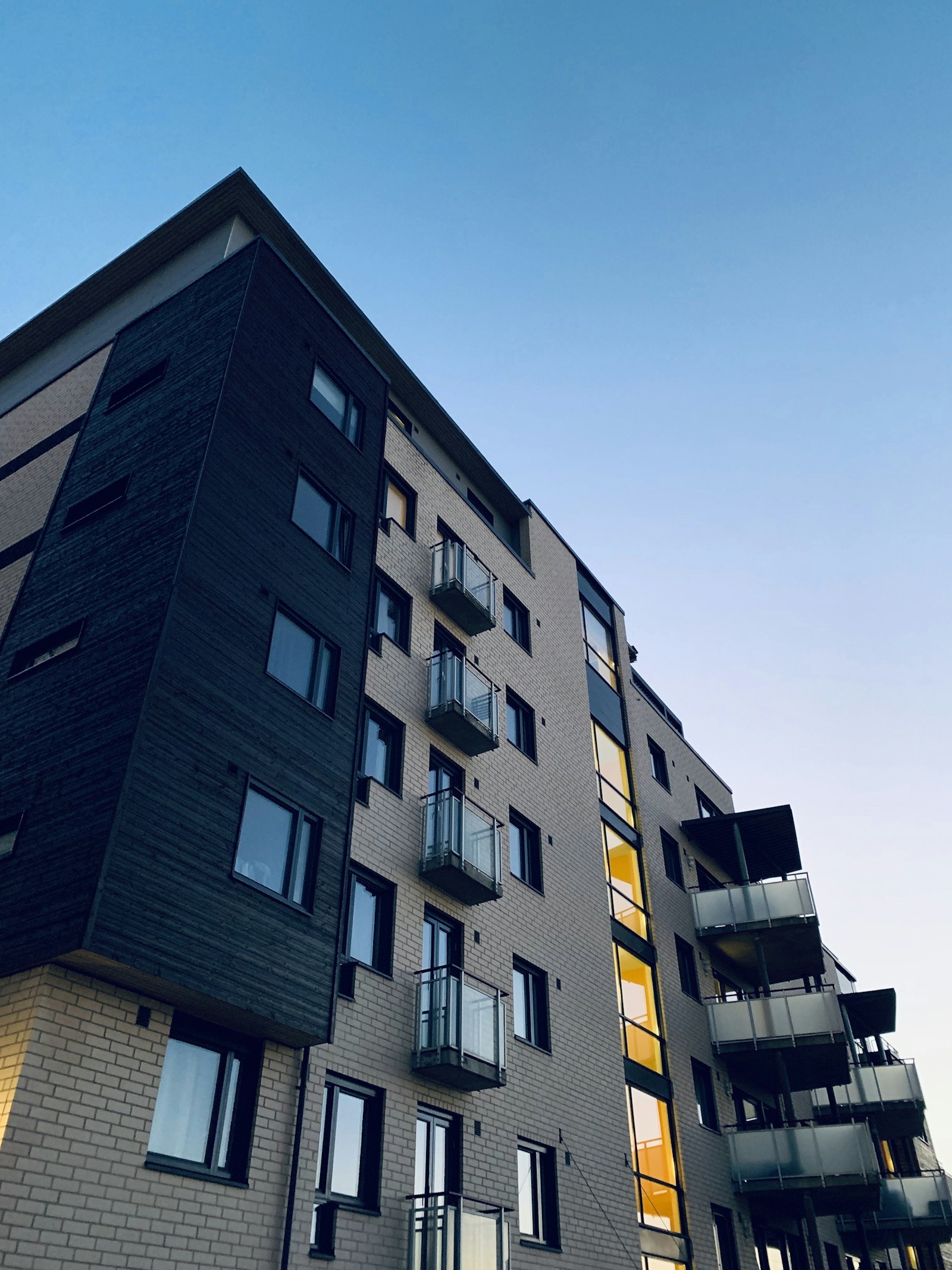 Modern luxury condominium tower exterior with glass facade and landscaped grounds